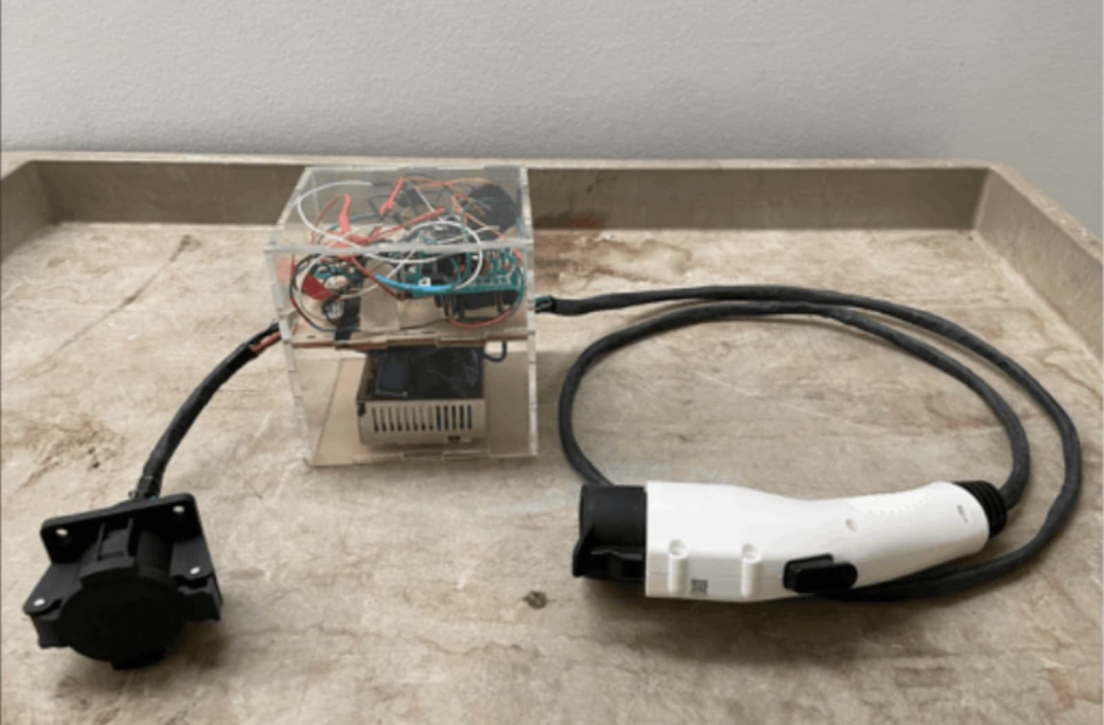The EVE charger prototype — acrylic enclosure with EV connectors